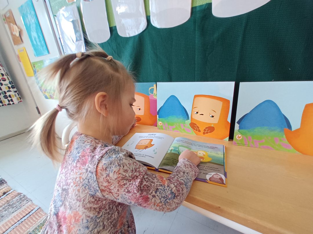 A child is learning emotional and social skills through reading Pikkuli's stories.